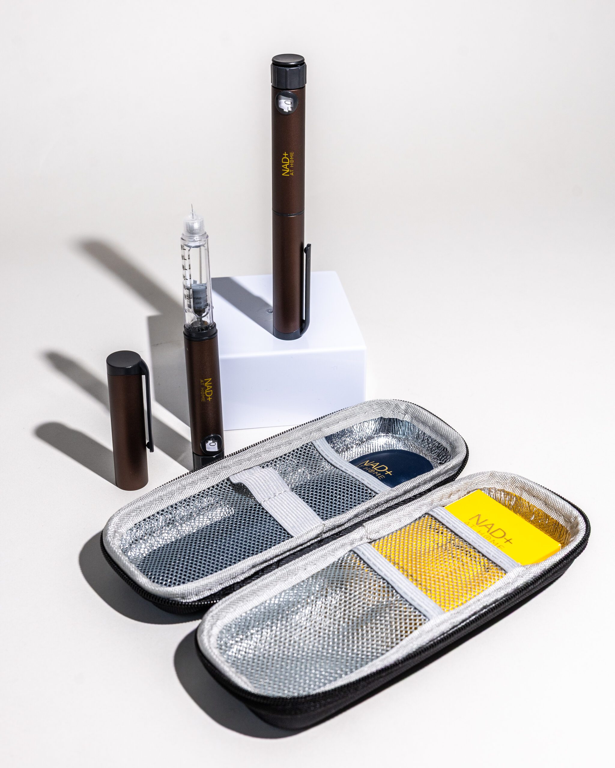NAD+ At Home Injection Pen Kit with open silver travel case, pen device, cartridge, and accessories arranged on a white surface.