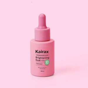 A 30ml bottle of Kairax Brightening Dual Serum with a pink dropper cap, featuring a label that reads "10% Niacinamide + 2% Alpha-Arbutin" on a light pink background.